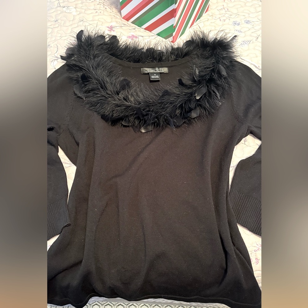 Party sweater w/ black feather collar making the perfect frame for your smile